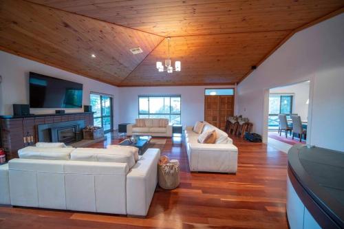 a living room with two white couches and a fireplace at The Hideaway by Gatt Wines in Craneford