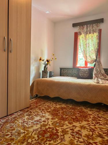1 dormitorio con cama y ventana en Căsuța Dede en Buzau
