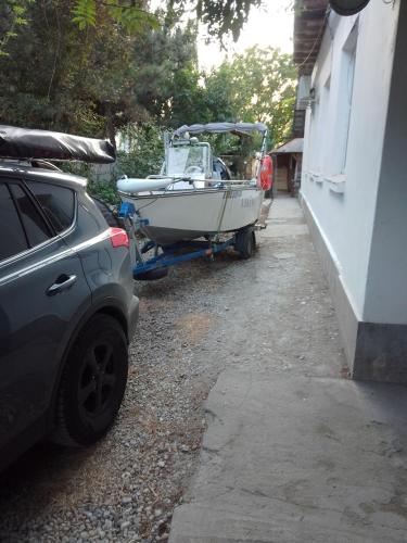 a boat parked next to a car next to a house at Casa Mocanu in Giurgiu