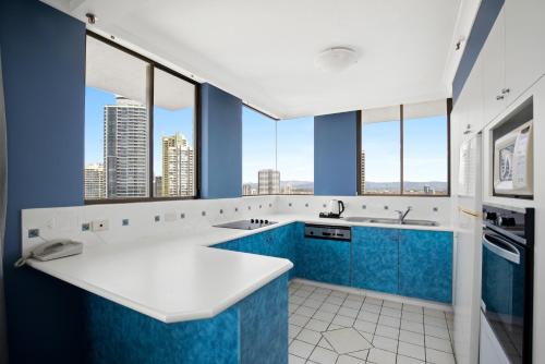 a bathroom with blue and white counters and windows at Capricorn One Beachside Holiday Apartments - Official in Gold Coast