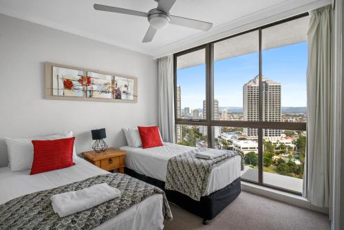 a bedroom with two beds and a large window at Capricorn One Beachside Holiday Apartments - Official in Gold Coast
