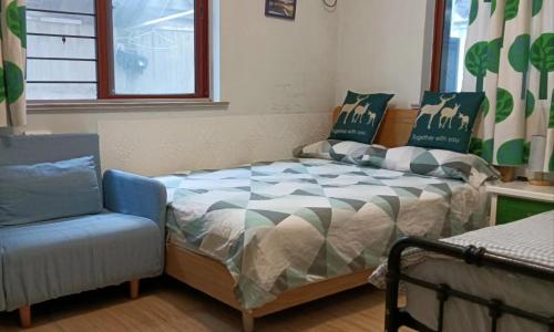 a bedroom with a bed and a chair and a window at Hangzhou Citynest Music B&B in Hangzhou
