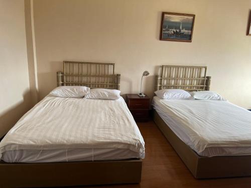 a bedroom with two beds and a lamp in it at CHINA STAR HOTEL in Kolonia