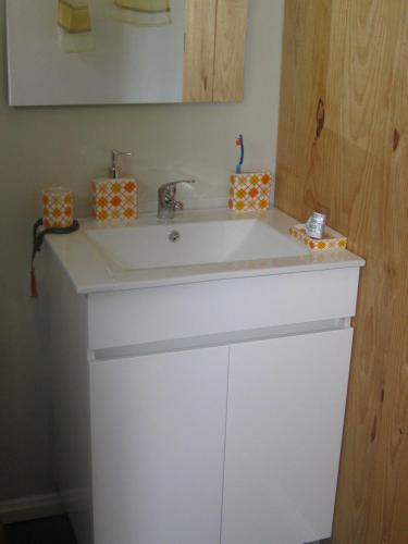 a bathroom with a white sink and a mirror at Cabana do Pinheiral in Ponte da Barca