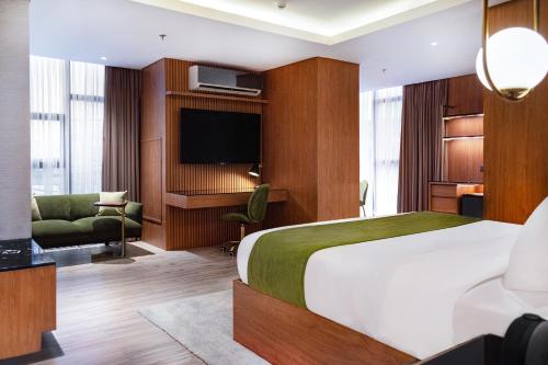 una camera d'albergo con letto e TV di Ironwood Hotel a Tacloban