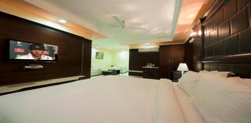 1 dormitorio con 1 cama y TV en la pared en Sun - A TAJ VIEW HERITAGE HOTEL, en Agra