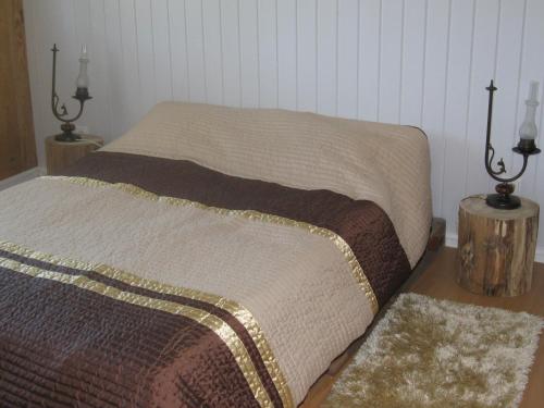 a bed in a bedroom with two lamps and two rugs at Casa Do Pinheiral in Ponte da Barca