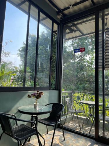 a patio with tables and chairs and large windows at The Safa Baiti Guest House Syariah in Rampal