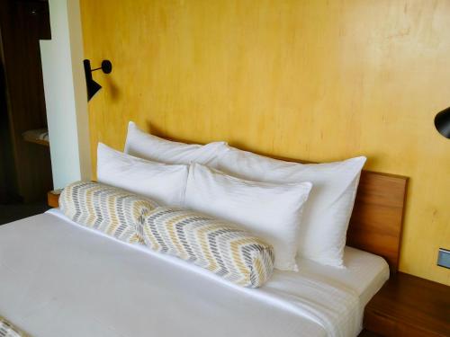 a bed with white pillows on top of it at GlenMyu Estate in Haputale