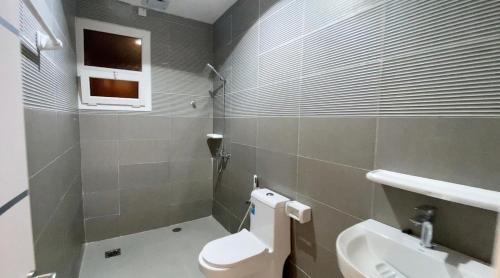 a bathroom with a toilet and a sink at La Vida Inn Quriyat 