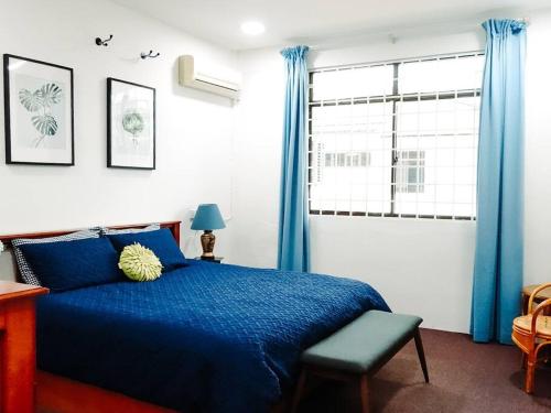 Un dormitorio con una cama azul y una ventana en Family Holiday House @Civic Centre Dewan Suarah, en Sibu