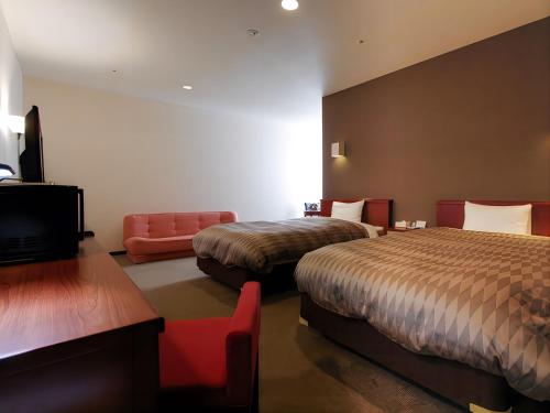 浜松市にあるホテルリブマックスBUDGET浜松駅前のベッド2台、薄型テレビが備わるホテルルームです。