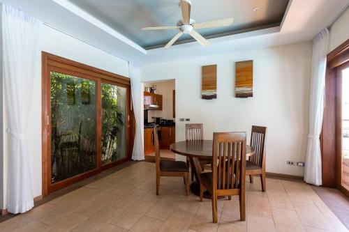 a dining room with a table and chairs and a ceiling fan at Villa Vigo with gym and tennis court in Koh Samui