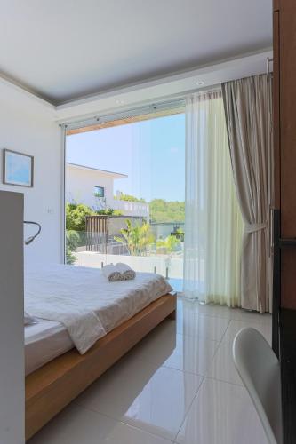 a bedroom with a bed and a large window at Вилла Vista Del Mare in Koh Samui