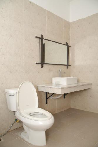 een badkamer met een toilet en een wastafel bij Tre Nguồn Thiên Cầm Hotel&Resort in Hưng Long