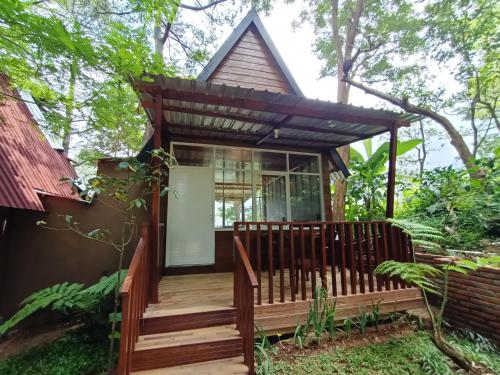 ein kleines Haus mit einer Holzterrasse und einer Glastür in der Unterkunft Pijar Resort Powered by Cocotel 