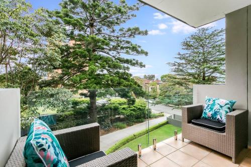 einen Balkon mit 2 Stühlen und einem großen Fenster in der Unterkunft HAR20 - 2 bedroom Harrison Street - Cremorne in Sydney