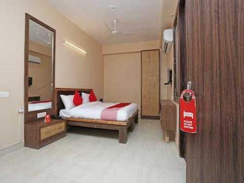 een slaapkamer met een bed met rode kussens bij OYO Flagship Grand Aashirwad in Ghaziabad