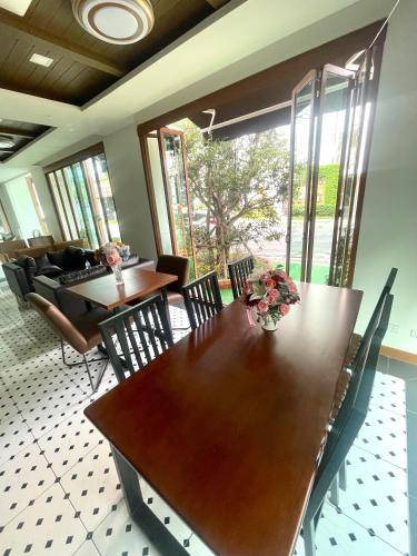 a dining room with a wooden table and chairs at Baannalin Hometel บ้านนลิน โฮมเทล in Chiang Mai