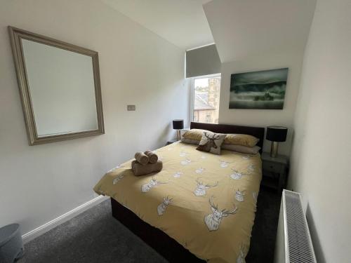 een slaapkamer met een bed met een teddybeer erop bij Crown àros beag, Ultra City Central 2 bedroom apartment with free parking onsite in Inverness