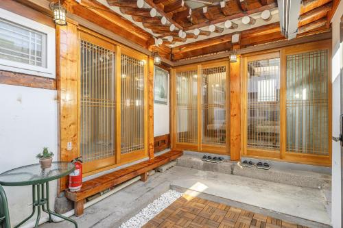 a room with wooden walls and windows with a table at Memory Stay Seoul Jongro Hanok in Seoul