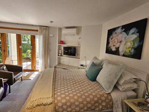 a bedroom with a bed and a living room at Parnell Garden Suite in Auckland