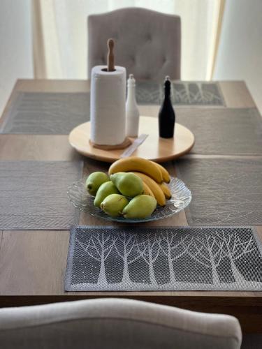 a table with a plate of fruit and a candle at Una in Bihać