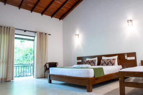 ein Schlafzimmer mit einem Bett und einem Balkon in der Unterkunft Tropicara Resort in Sigiriya