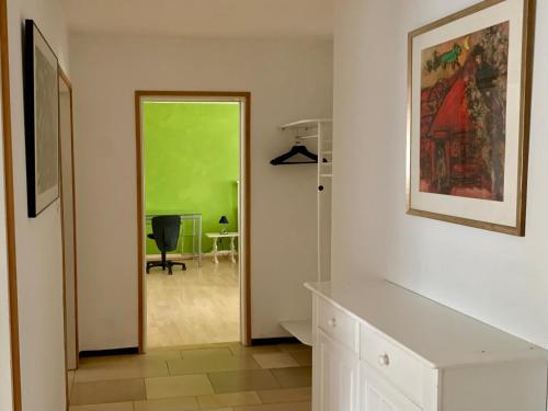 a hallway with a door leading to a green room at Wohnen am Wasserschloss Sandizell in Schrobenhausen