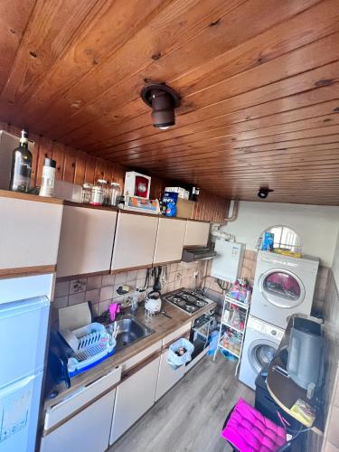 a kitchen with a sink and a washing machine at 2de double bed room in The Hague