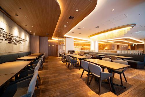 a dining room with tables and chairs in a restaurant at Hotel JAL City Nagoya Nishiki in Nagoya