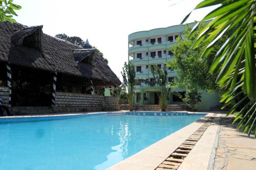 a swimming pool in front of a building at Greenyard Resort Mtwapa in Mtwapa