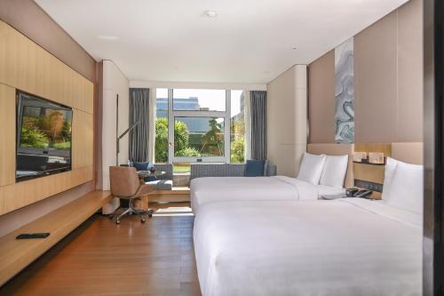 a hotel room with two beds and a desk at Courtyard by Marriott Shenzhen Northwest in Bao'an