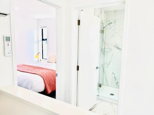 a bedroom with a shower and a bed with a red blanket at CHCH centre Luxury townhouse close to CBD in Christchurch