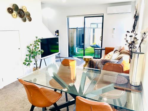 a living room with a glass table and chairs at Christchurch CBD Luxury townhouse in Christchurch