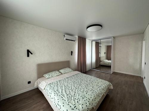 1 dormitorio con cama y espejo en Квартира в историческом центре en Chernihiv