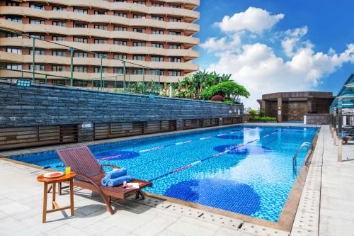 a swimming pool in front of a building at Pullman Foshan Shunde-Canton Fair Shuttle Bus at Extra RMB100 per Person Daily in Shunde
