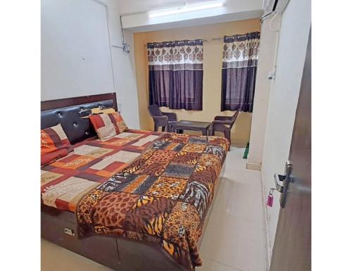 馬圖拉的住宿－Hotel Saurav Palace, Mathura，一间卧室配有一张床和椅子