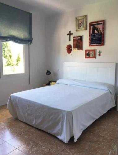 ein großes weißes Bett in einem Schlafzimmer mit Fenster in der Unterkunft Apartamento renovado en Cadaqués in Cadaqués