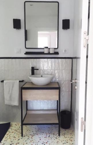 Apartamento renovado en Cadaqués في كاداكيس: حمام مع حوض ومرآة