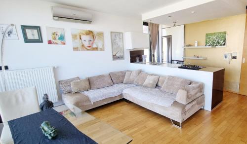 ein Wohnzimmer mit einem Sofa und einer Küche in der Unterkunft Bella Vista Lux Apartment with private Terace in Koper