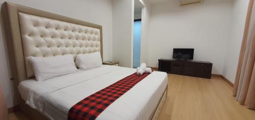 um quarto com uma cama grande e um cobertor xadrez em THE ELEMENTS JALAN AMPANG em Kuala Lumpur