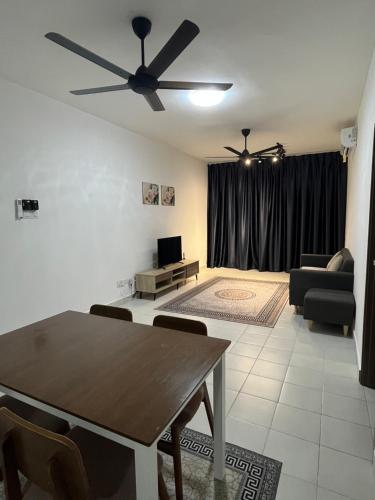 a living room with a table and a ceiling fan at Residensi Afamosa in Kampong Alor Gajah