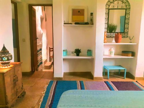 a room with a bed and a mirror on the wall at Cortijo Los Maximos in Turón