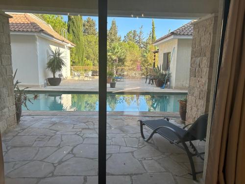 a view of a swimming pool from a sliding glass door at Luxury Kouklia Apartments in Kouklia