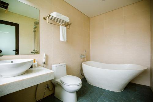 y baño con bañera, aseo y lavamanos. en Lam Anh Hotel Him Lam Vạn Phúc Hà Đông en Hà Ðông