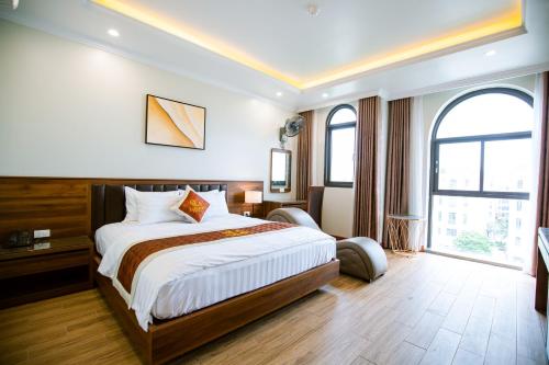 a hotel room with a bed and a large window at Lam Anh Hotel 5 Him Lam Vạn Phúc in Hà Ðông