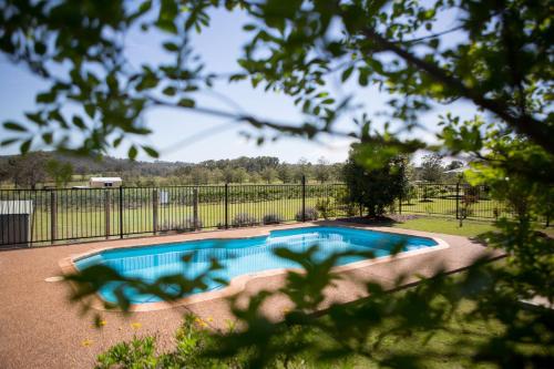 ein Pool in einem Garten mit einem Zaun in der Unterkunft Bluebush Estate Retreat in Lovedale