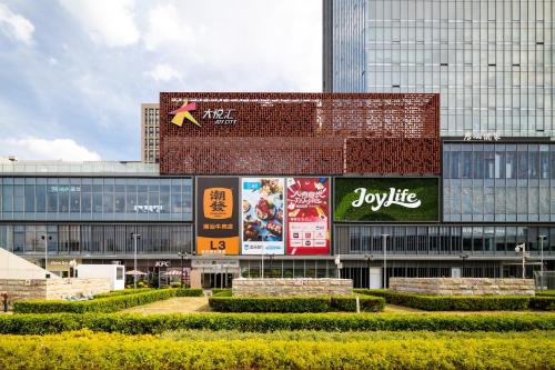 un grand bâtiment avec des panneaux sur son côté dans l'établissement Livetour Hotel Kehui Golden Valley Guanzhou, à Canton