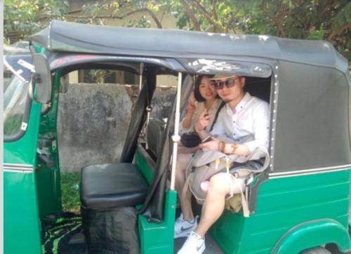 a man and woman sitting in the back of a golf cart at Sunrise City Palace in Negombo
